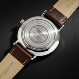 Watch with brown leather strap and visible brand name on a white background