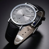 Black wristwatch with a silver watch face on a white background