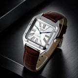 A rectangular silver-tone metal wristwatch with a white dial, Roman numeral hour markers, blue hands, and a brown leather strap, photographed on a dark brushed surface.