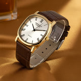 Watch with brown leather strap and gold case on a white background