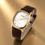 Watch with brown leather strap and gold case on a white background